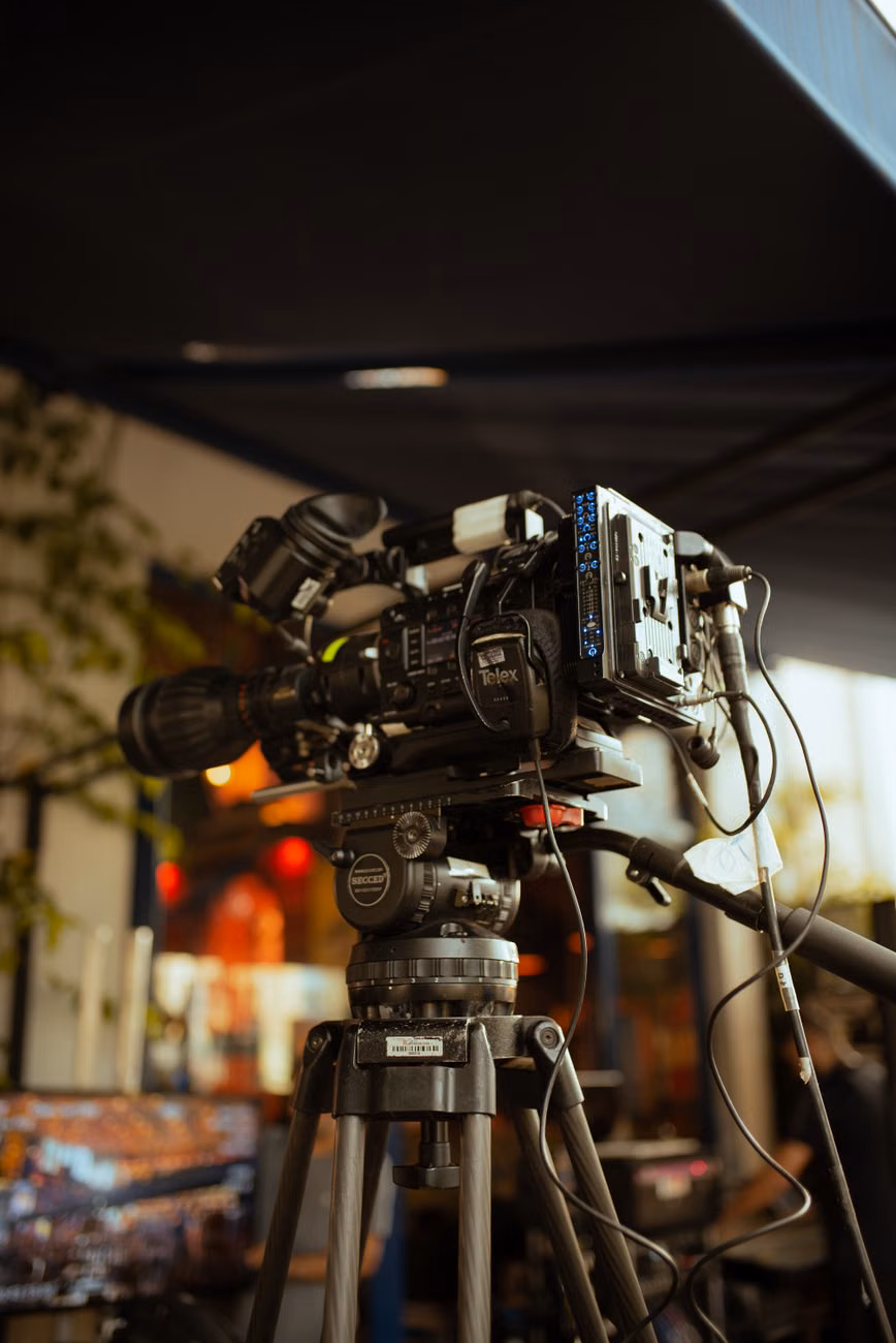 High-quality video camera setup on a tripod for outdoor filming.